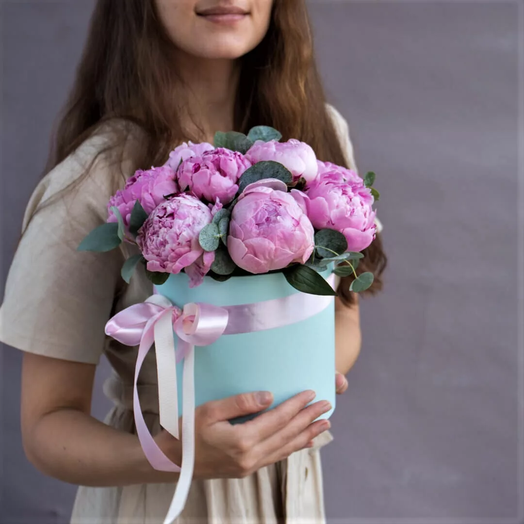 Flower arrangement of 9 pink peonies in a hat box